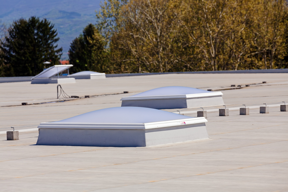 White flat roof with ventilated frosted skylights.